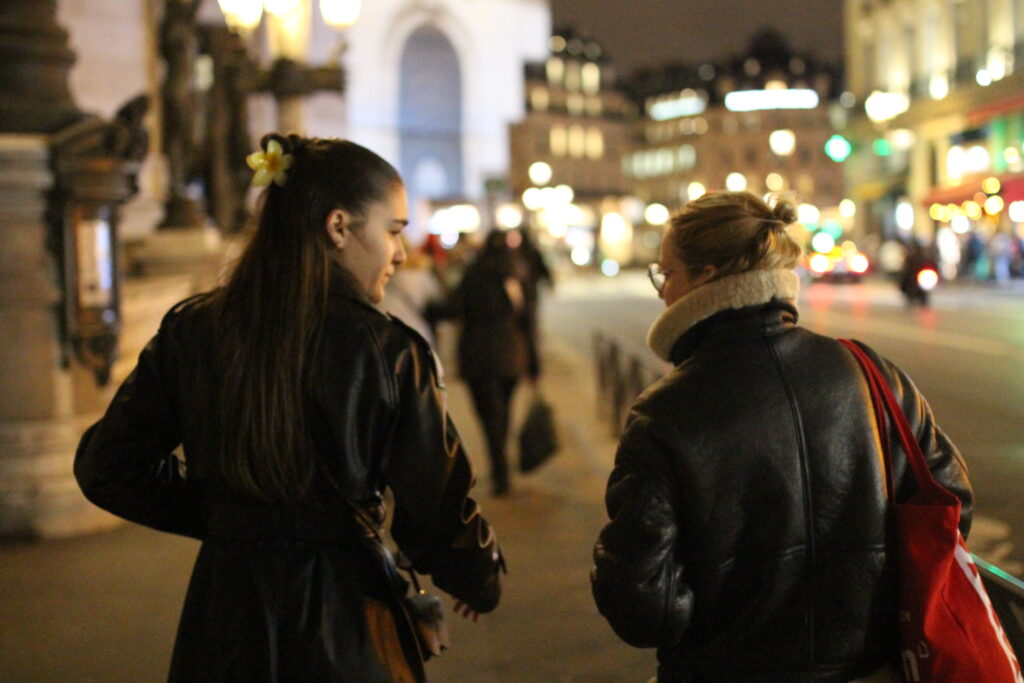 Deux personnes marchant de dos dans le quartier animé de l'Opera Garnier à Paris