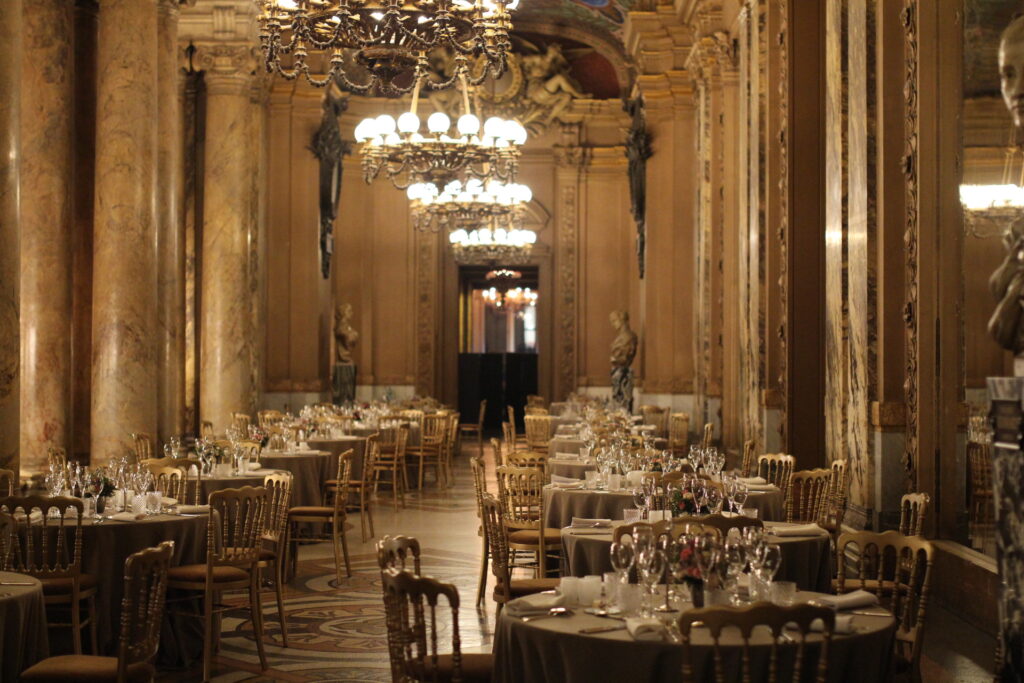 Le Grand Foyer de l'Opéra Garnier à Paris avec des tables dressées pour un repas.