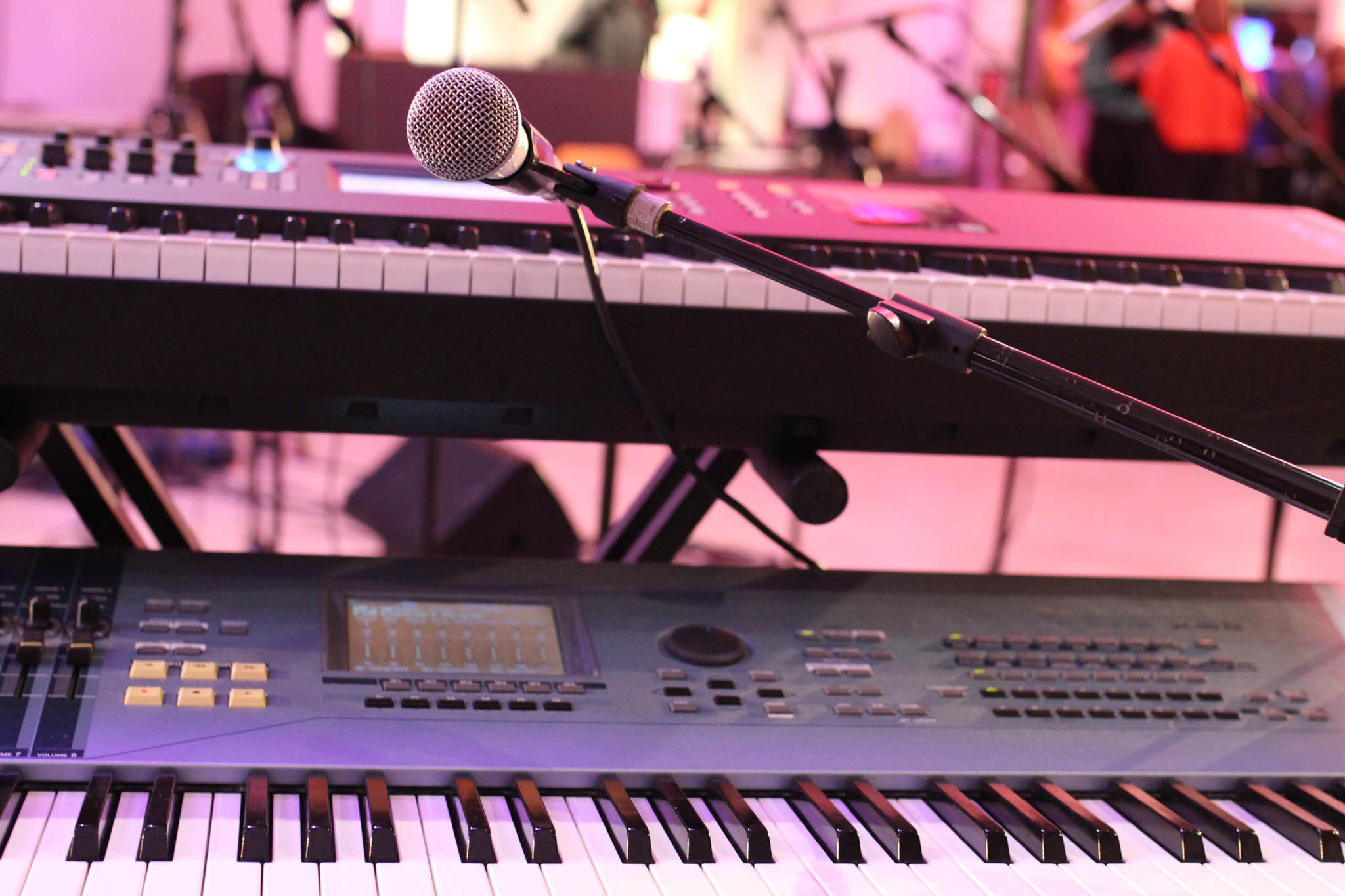 deux pianos synthétiques dans une salle de concert et un micro sans-fil entre les deux.