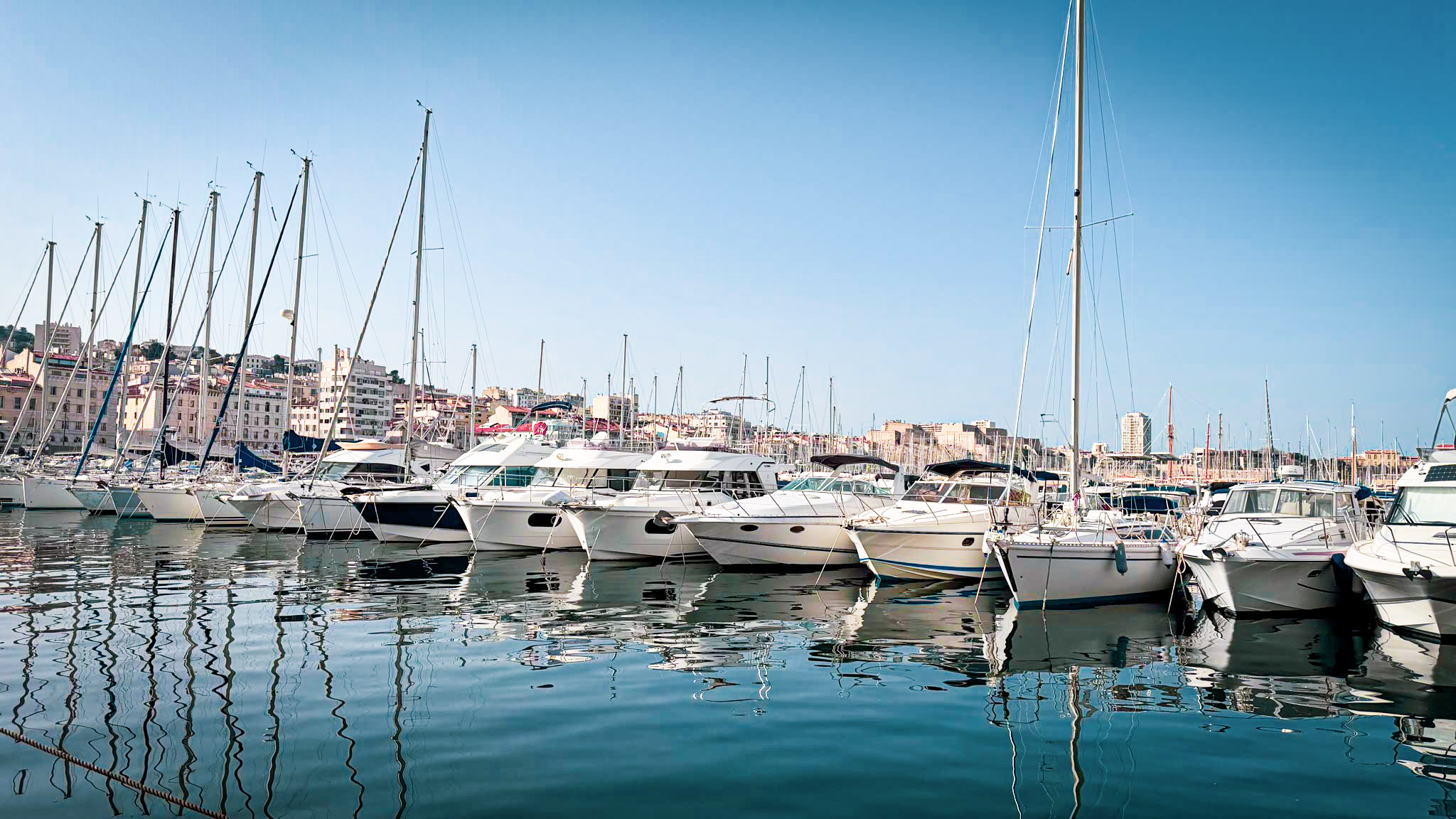 Boats docked in a harbor under a blue sky