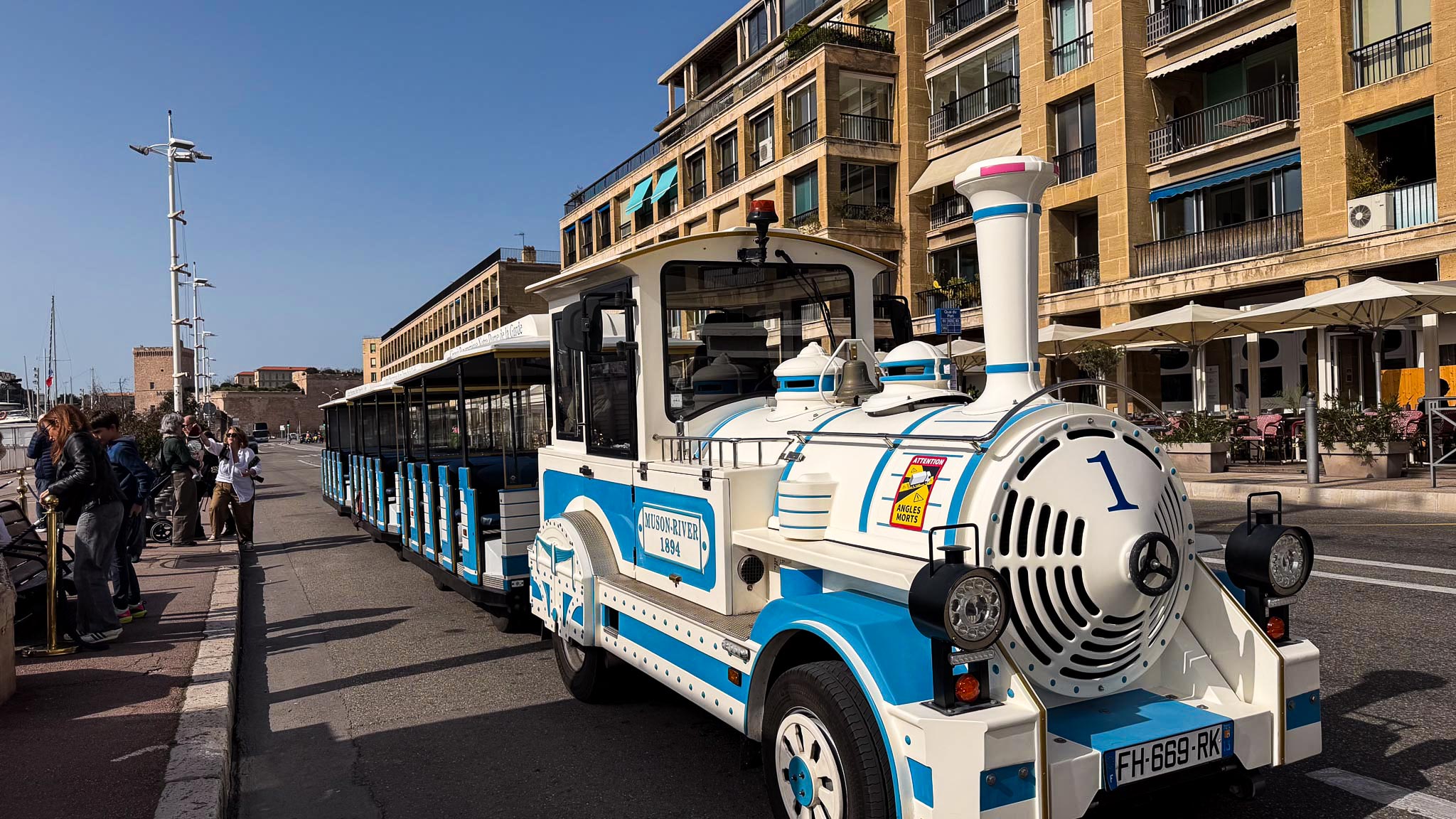 Small light blue and white tourist train in the city center