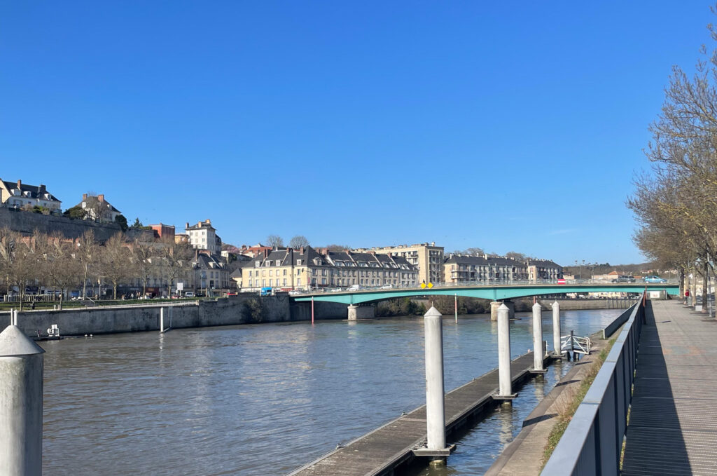 Vue sur les quais de l'Oise à Pontoise, avec le pont et la vieille ville en arrière-plan – lieu idéal pour un team building à Cergy-Pontoise