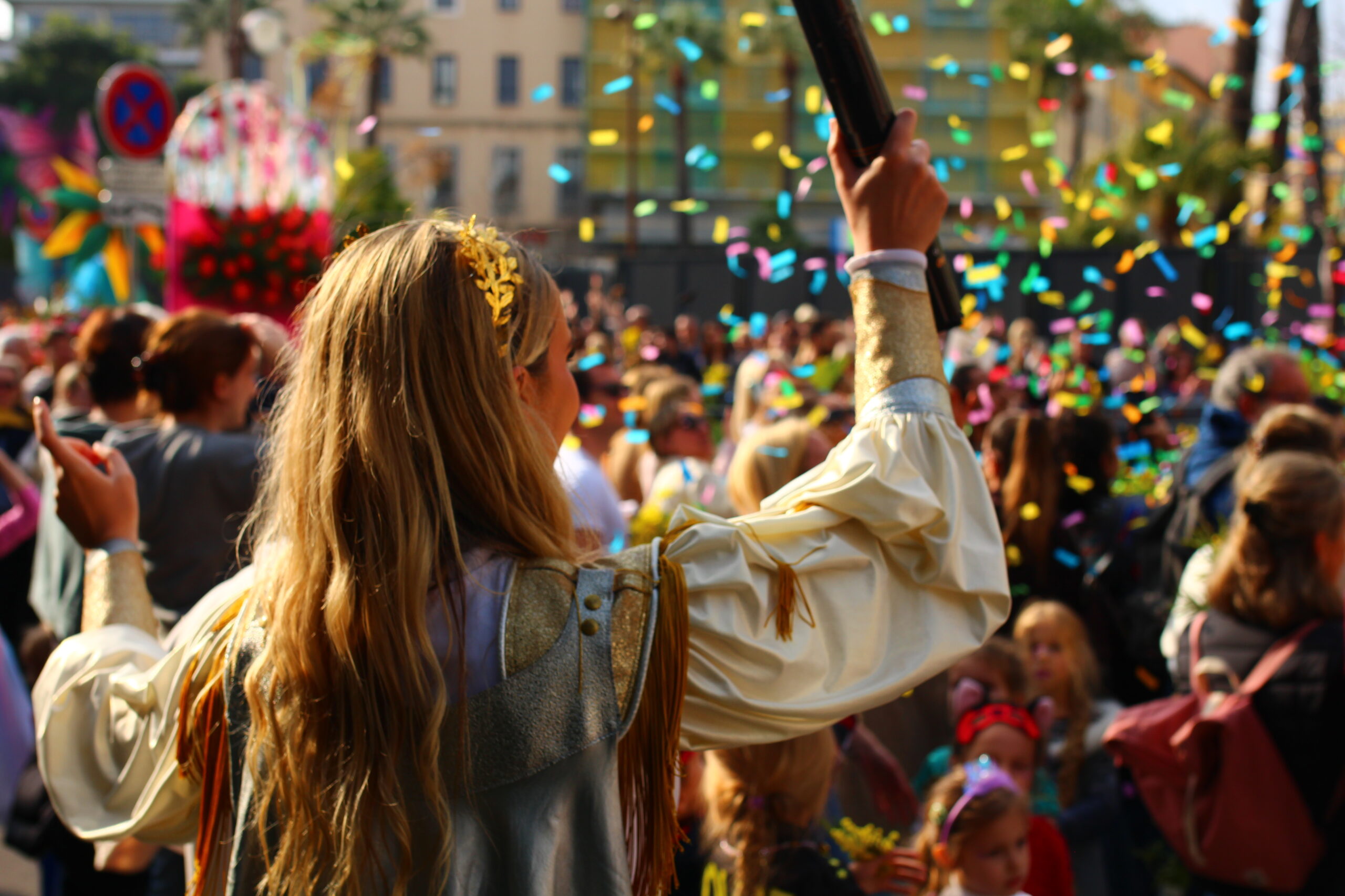 une femme de dos vient de lancer des confettis sur le public pendant un événement.