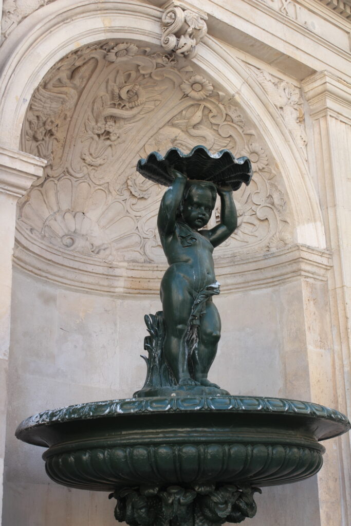 Baby fountain holding a seashell in Paris