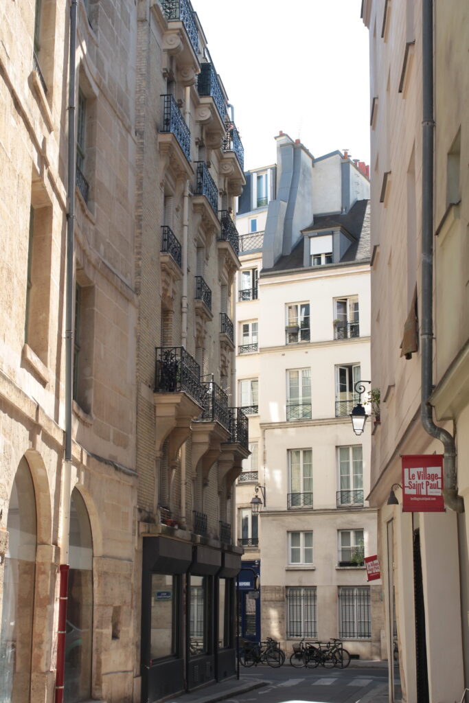 Rue de paris qui cache le soleil avec les grands bâtiments 