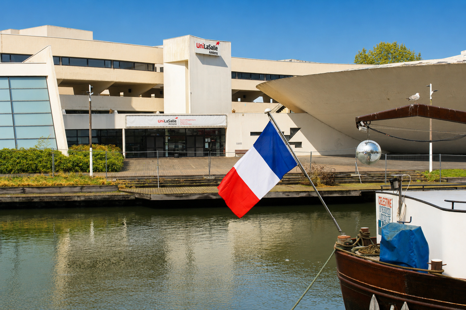 canal d'Amiens ensoleillé avec un bateau et un drapeau français