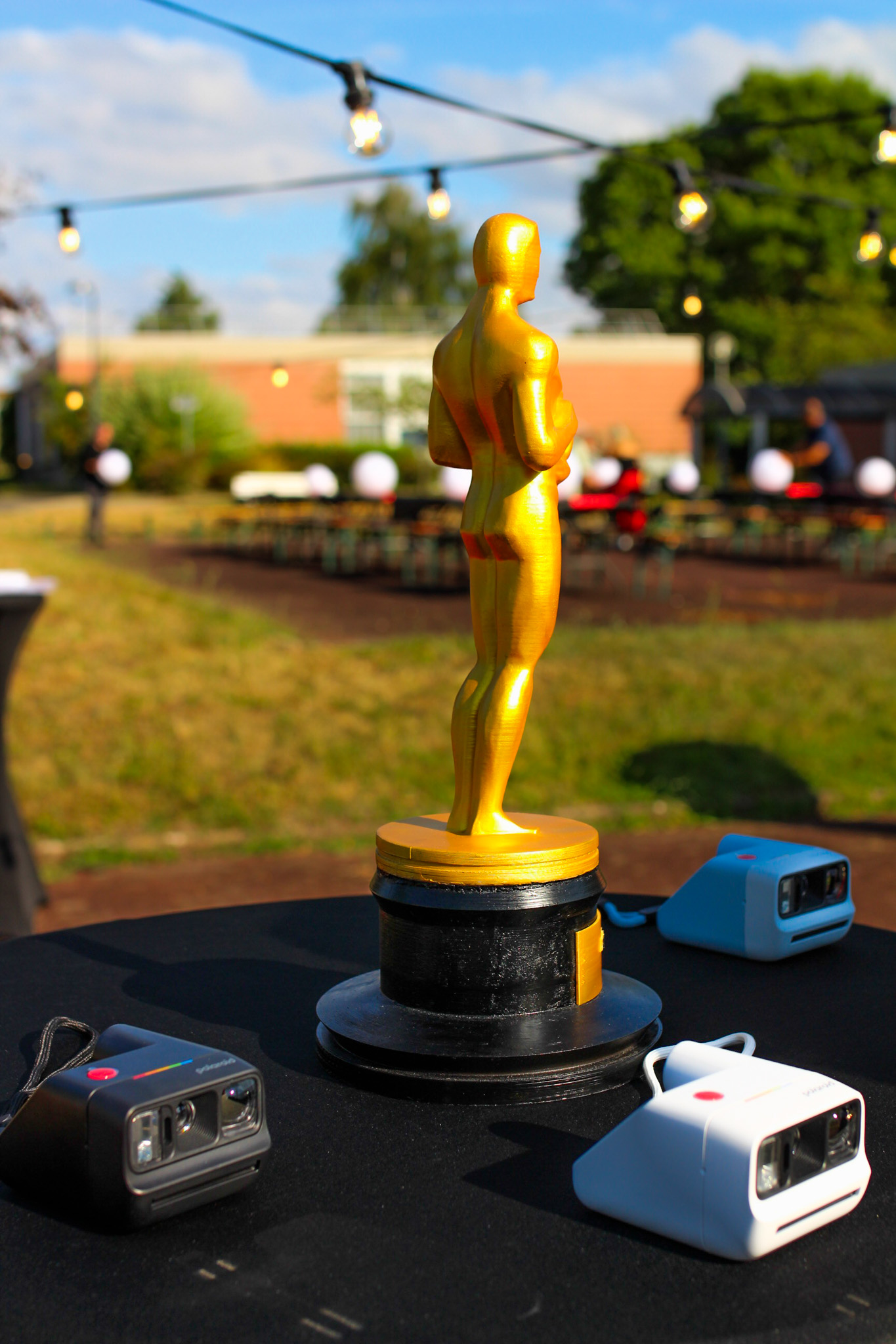 une statue des oscars entourée d'appareils photos instantanés.