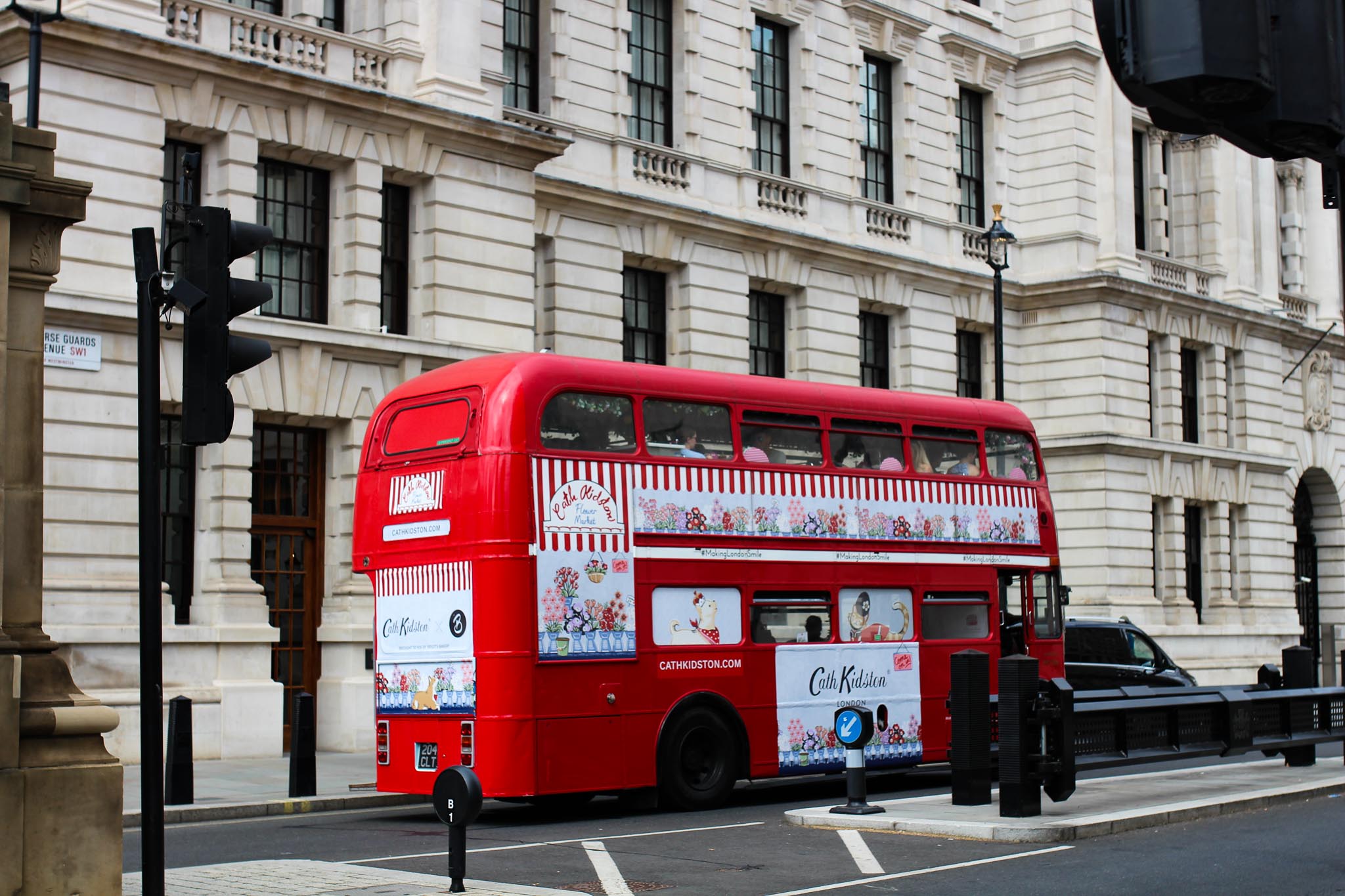 a red London double-decker bus in the city streets.
