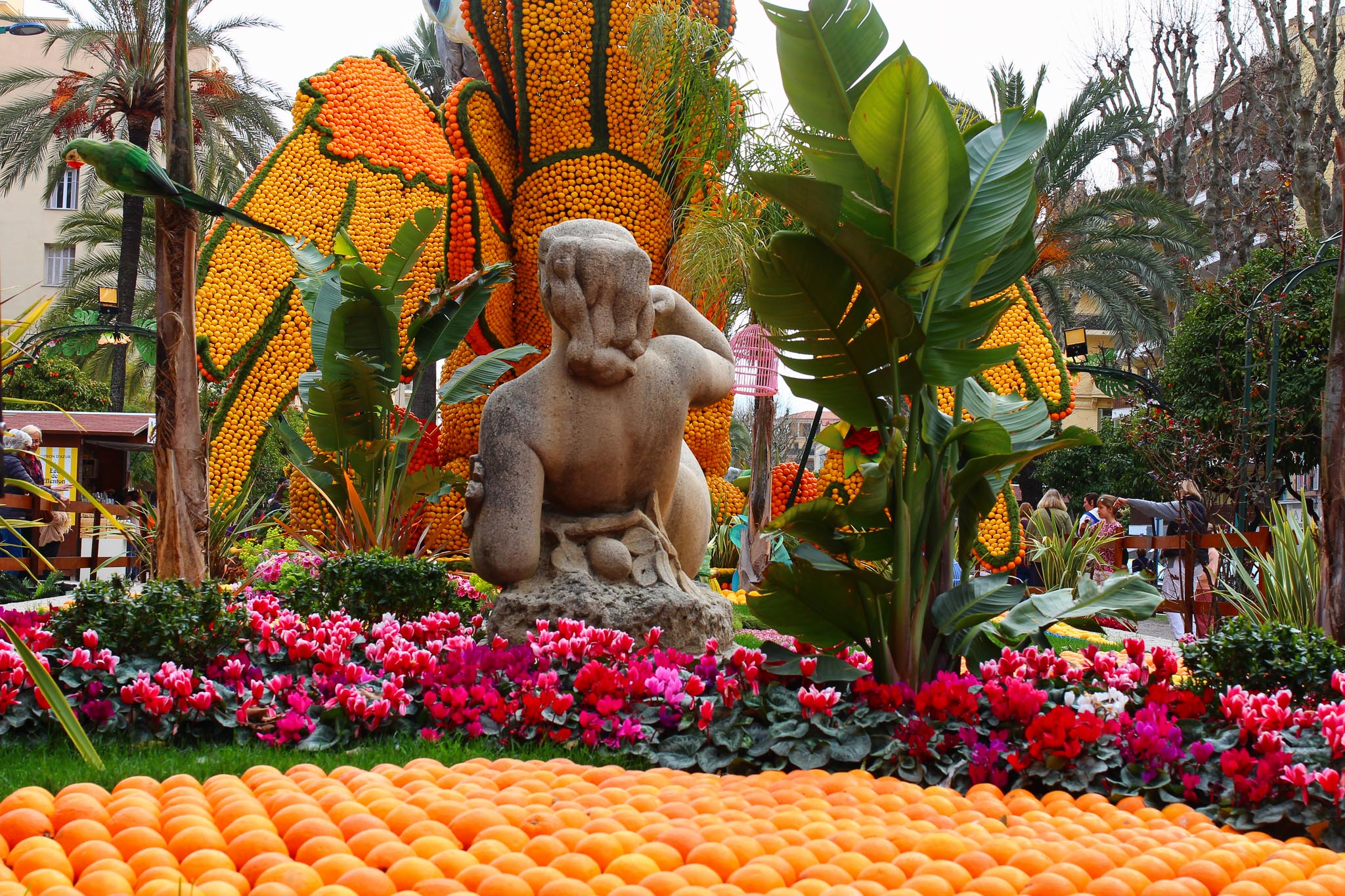 une création dans un jardin avec un statue en pierre et des citrons et agrumes pour le décors lors de la fête du citron à Menton