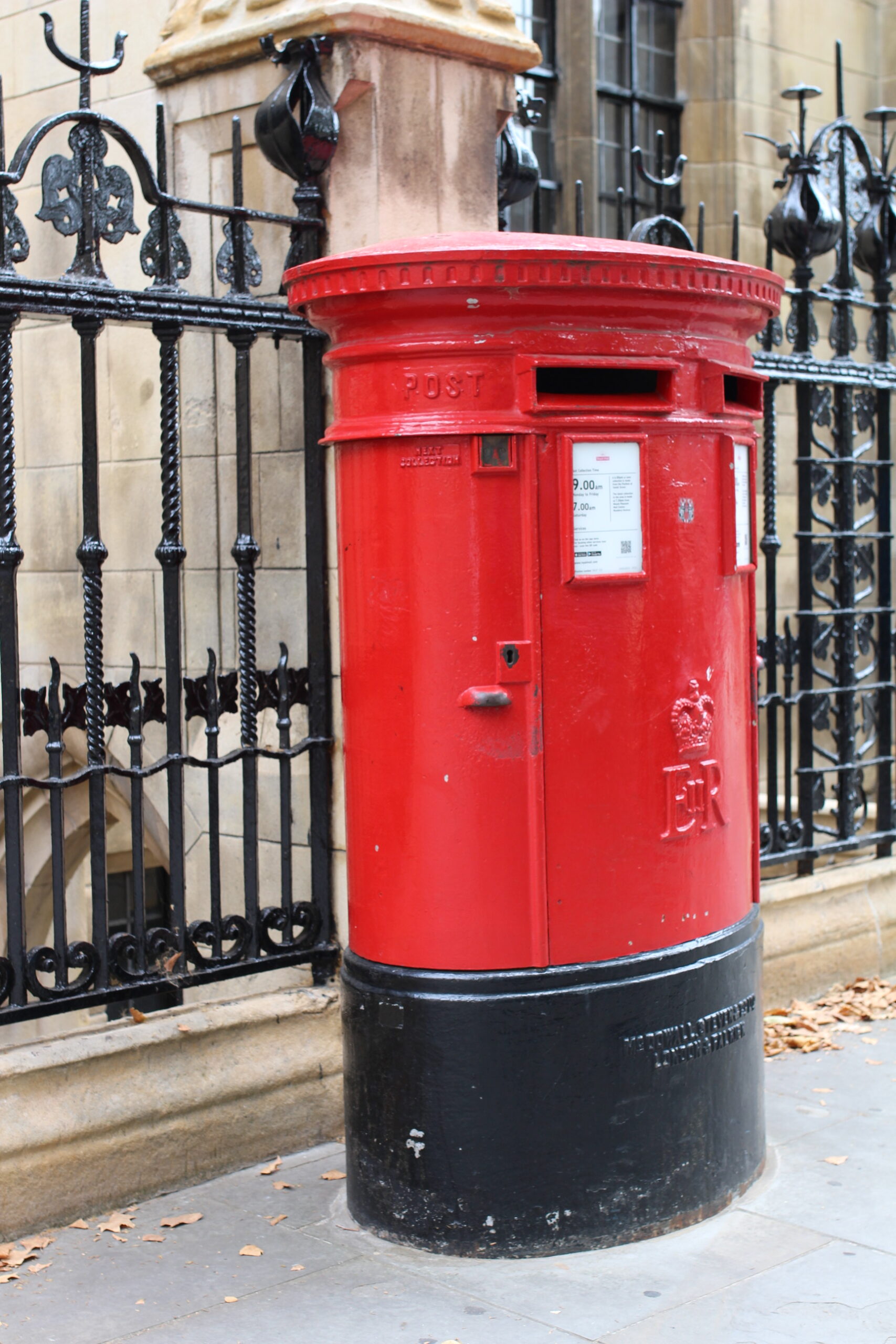 red and black mailbox in a street in London