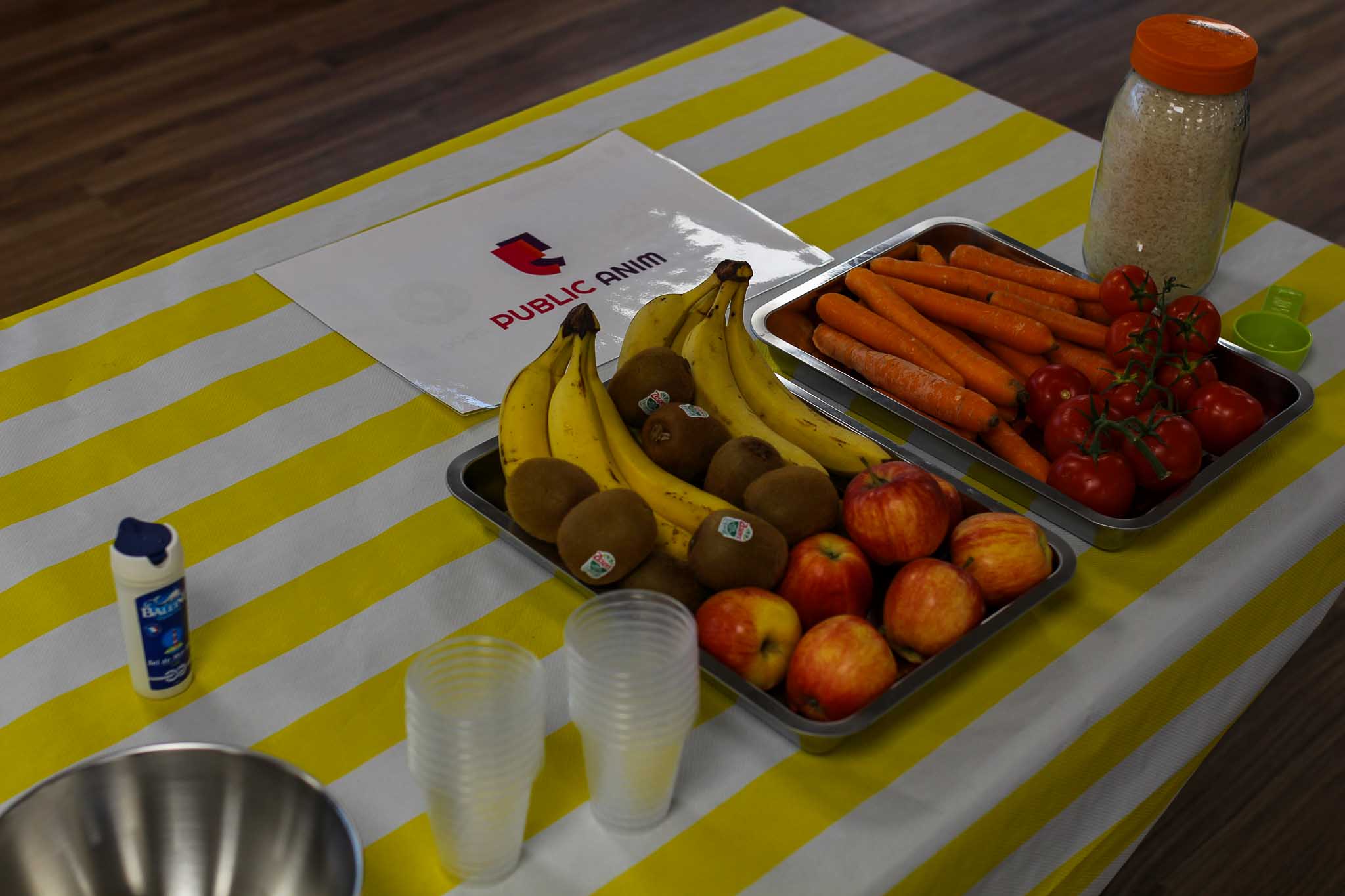 table avec une nappe, et deux plateaux en Inox avec fruits et légumes.
