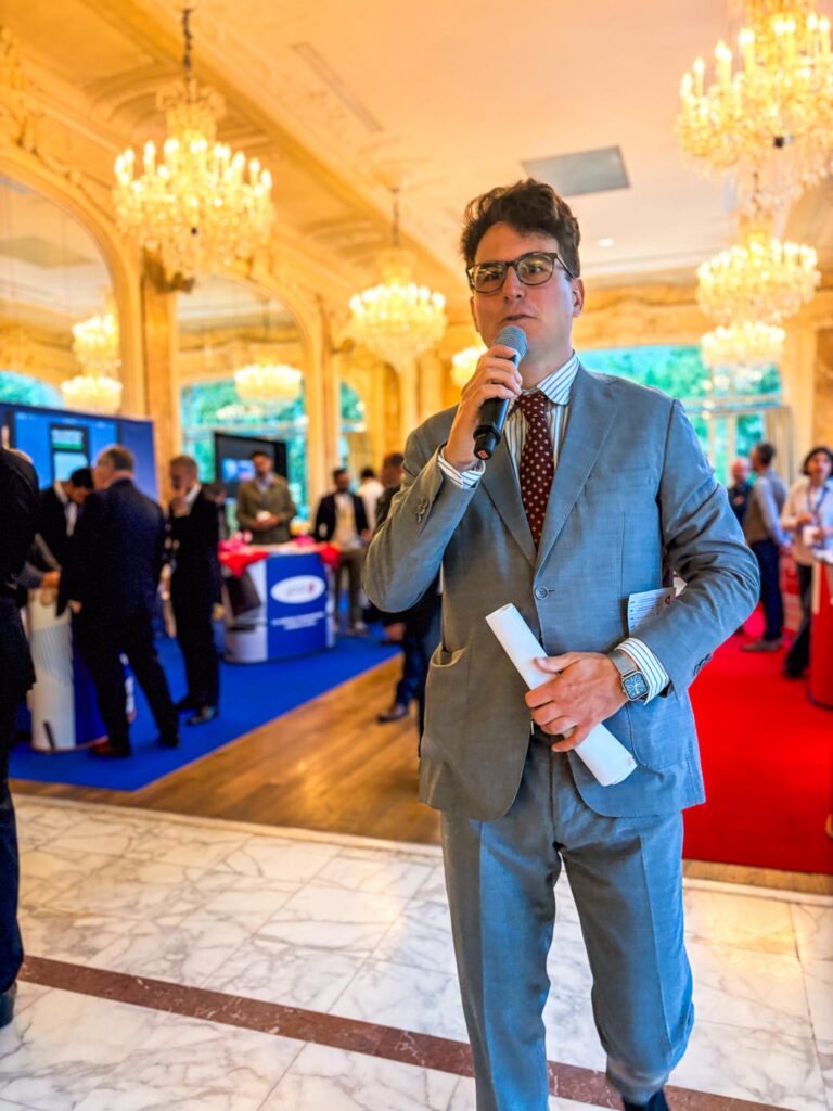 un animateur au micro dans un salon d'un hôtel particulier à Paris